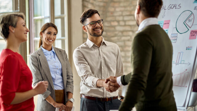 happy-coworkes-shaking-hands-after-business-presentation-office